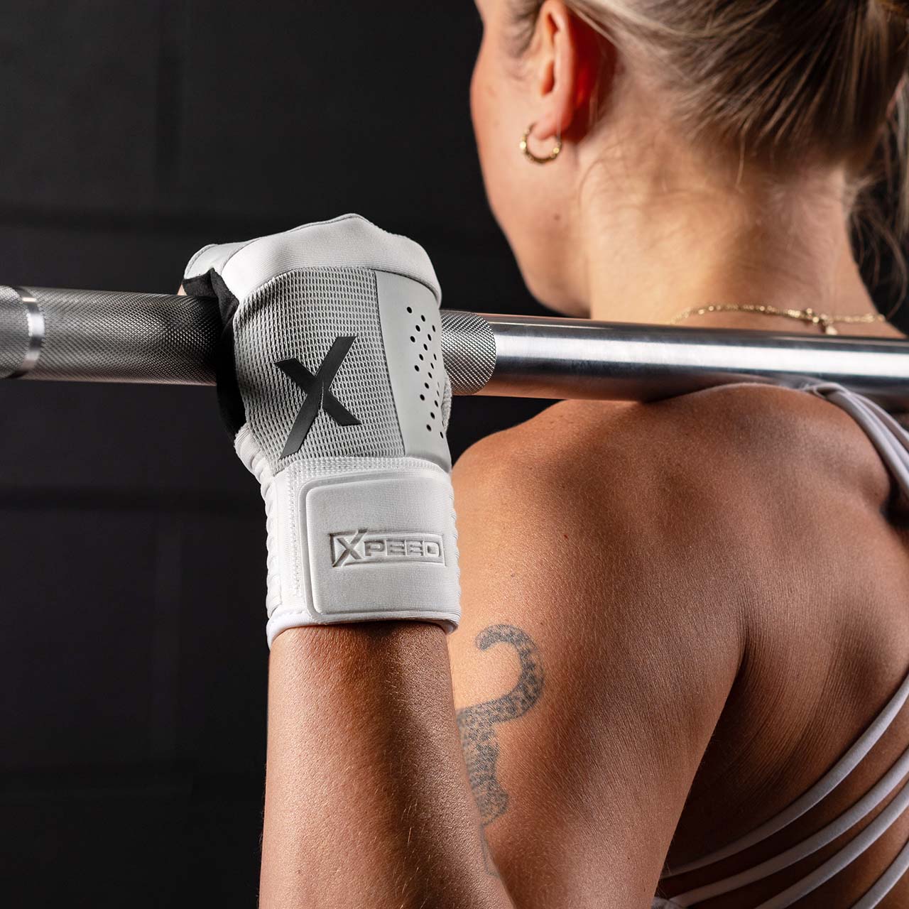 Person lifting a barbell with a womens xpeed hybrid weight lifting glove