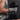Person holding a black dumbbell wearing xpeed armour pro weight lifting gloves with a visible brand logo.